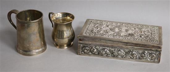 Two silver christening mugs and a white metal cigarette box.